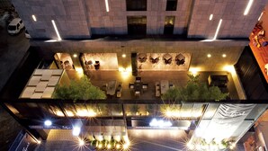 An aerial view of a hotel with outdoor seating areas, a rooftop garden, and a modern design. - Lee Design Hotel (Yongin)