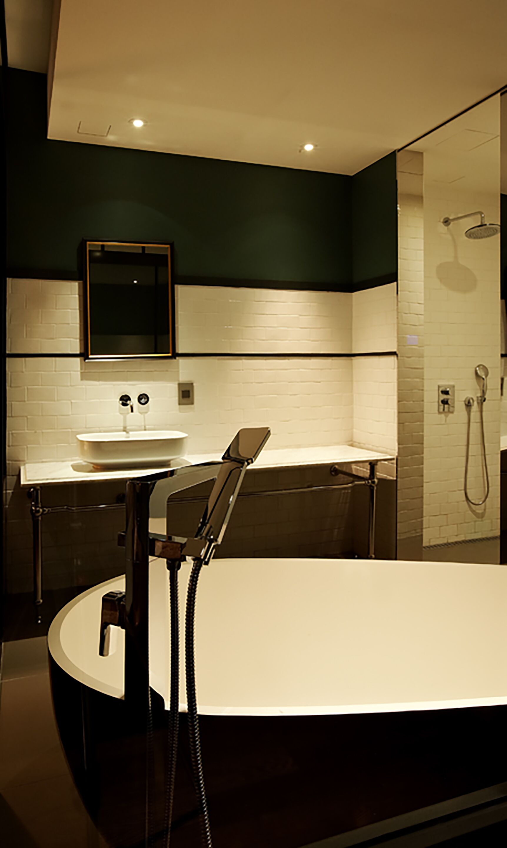 Une salle de bain moderne avec une grande baignoire, un lavabo avec un miroir au-dessus et un espace douche.
