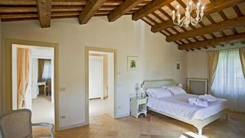 Ein Schlafzimmer mit einem Bett, einem Sessel, einem Schreibtisch und einer Chandelüster.