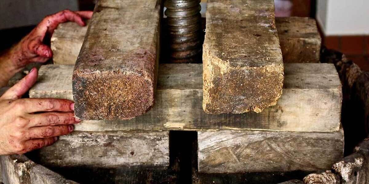 Eine hölzerne Bank mit zwei großen, grob strukturierten Blöcken darauf.