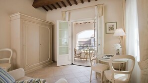 Una habitación con un armario amplio, un comedor con sillas y una mesa, y vista a un balcón exterior a través de una puerta abierta.