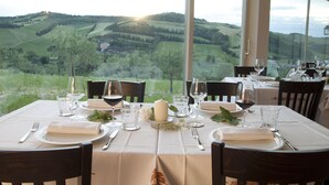 Mesa lista para comer con una vista panorámica de colinas onduladas y un castillo a lo lejos.