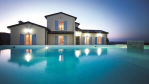 Una casa grande de dos pisos con piscina delantera.