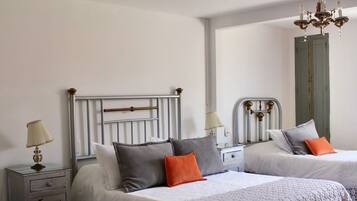 Una camera da letto con due letti, un lampadario e un armadio.