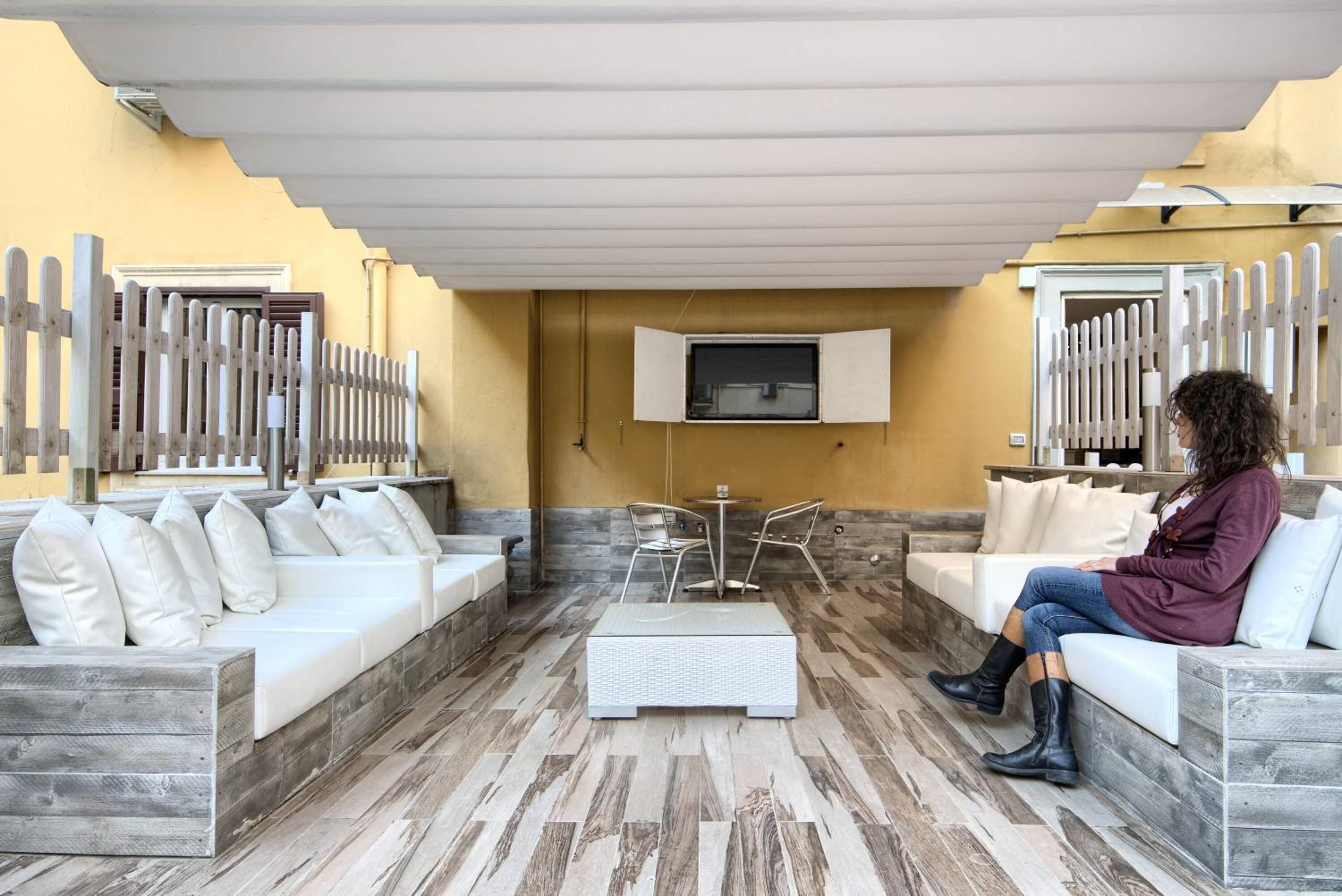 Un espace extérieur aménagé avec un canapé, une petite table et des chaises.