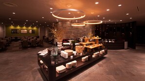 Eine moderne Hotelhalle mit einer Rezeption, einer Sitzecke und einem Buffet.