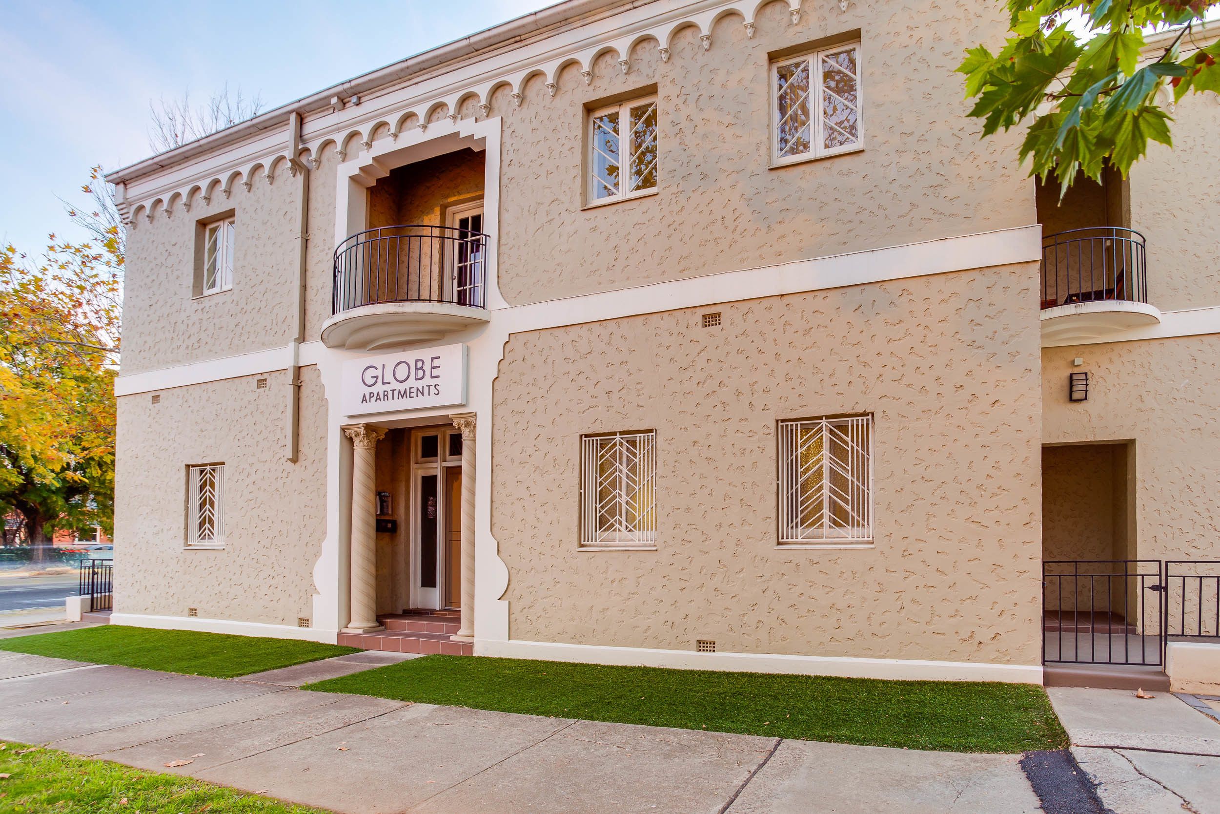 A two-story building with a sign reading "GLOBE APARTMENTS".