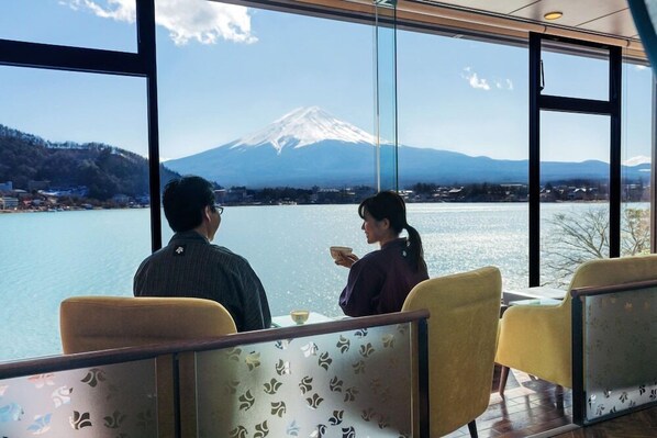 A dining area with a view of a mountain and lake.