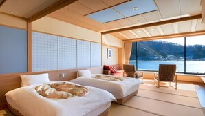 A hotel room with two beds, a view of the sea, and tatami flooring. - Ubuya (Fujikawaguchiko)