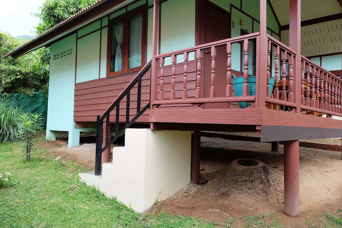 Un edificio de dos pisos con un balcón de madera y una pequeña escalera que conduce al piso superior.