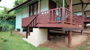A two-story building with a wooden balcony and a small staircase leading to the upper floor.