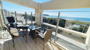 A balcony with a glass table and chairs, overlooking a coastal view. - Breath Hotel (Fujisawa)