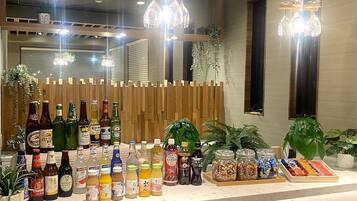 A bar area with various bottles and jars of beverages, wooden decor, and hanging lights.