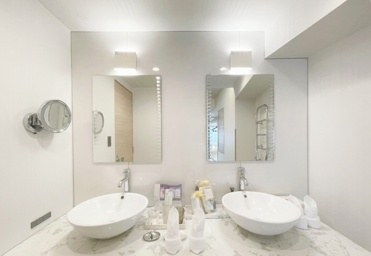 A bathroom with two sinks, a mirror, and a towel rack.