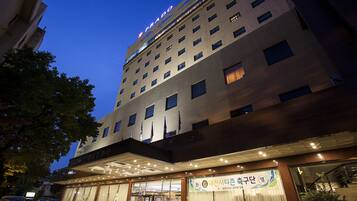 A hotel with a modern facade, multiple floors, and a prominent entrance with glass doors.