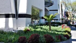 A modern hotel with a unique angular design, featuring a prominent sign for the Real Alamedas Hotel. - Hotel Real Alameda (Querétaro)