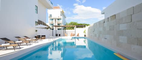 Alberca al aire libre y camastros