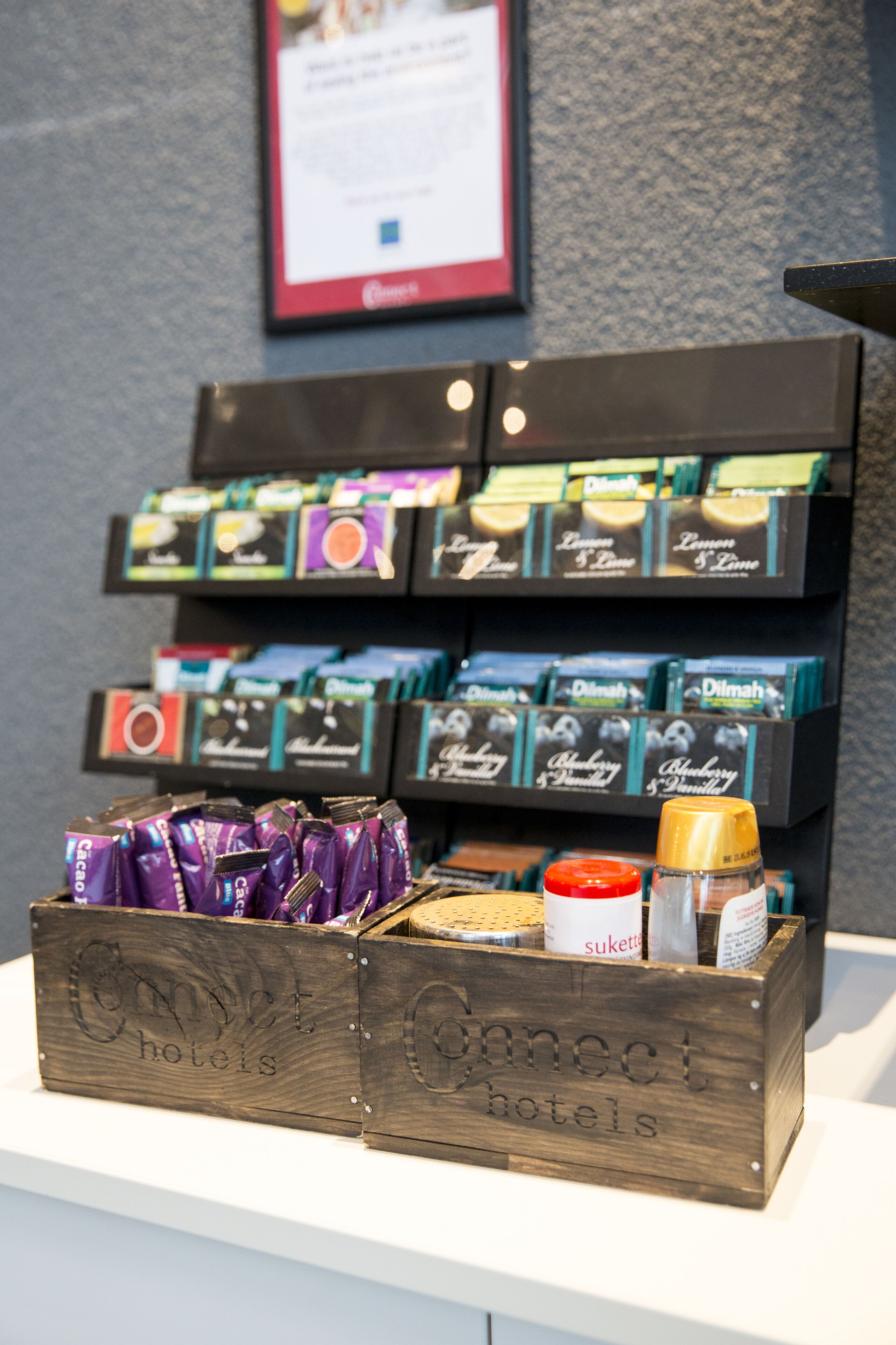Una exhibición de alimentos envasados y una caja de madera con la etiqueta 'Connect Hotels' y varios productos alimenticios.
