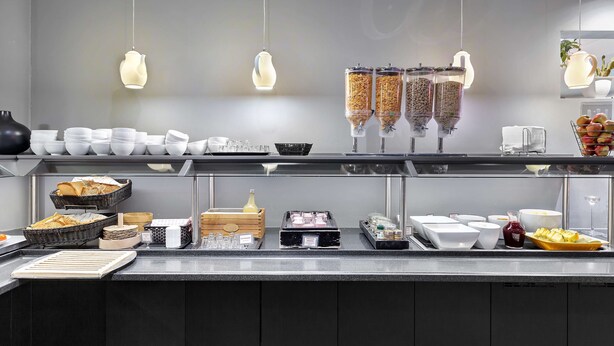 Un'attrezzatura per buffet con diversi alimenti e contenitori, tra cui ciotole, cesti e distributori di condimenti.