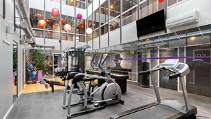 Una palestra moderna con tapis roulant, macchinari ellittici e attrezzature per l'allenamento con i pesi.