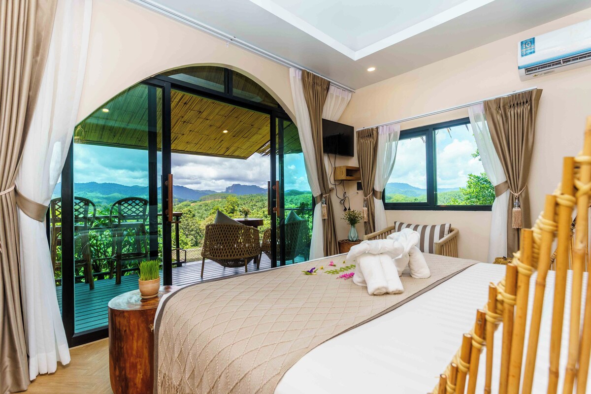 Un dormitorio con una cama grande, televisión y vistas al exterior.