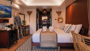 Habitación de hotel con cama, escritorio, televisión, aire acondicionado y vistas a la ciudad.