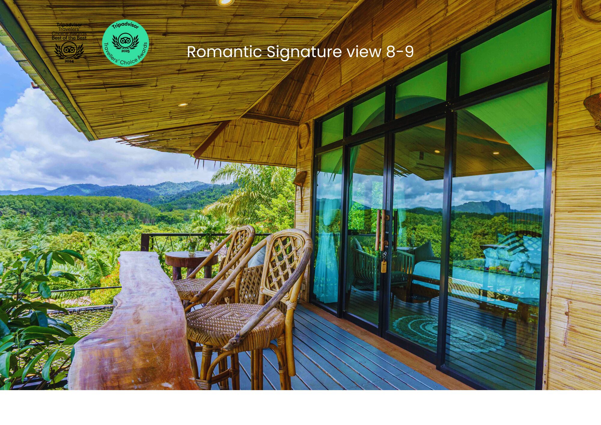 Terraza de madera con sillas de mimbre y una mesa con vista a un paisaje exuberante.