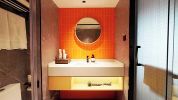 A bathroom with a white sink, a round mirror, and orange tiles.