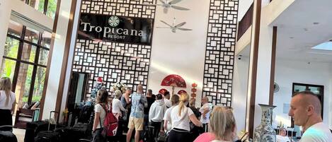 A Tropicana Resort lobby with a modern design, including a patterned wall and ceiling fans.