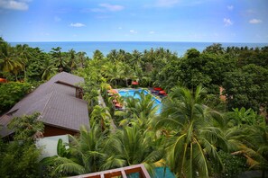A tropical resort with a swimming pool surrounded by lush greenery and palm trees, overlooking a beach. - Tropicana Resort (Phu Quoc)
