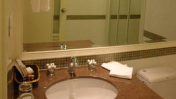 Un baño con lavabo, espejo y ducha.