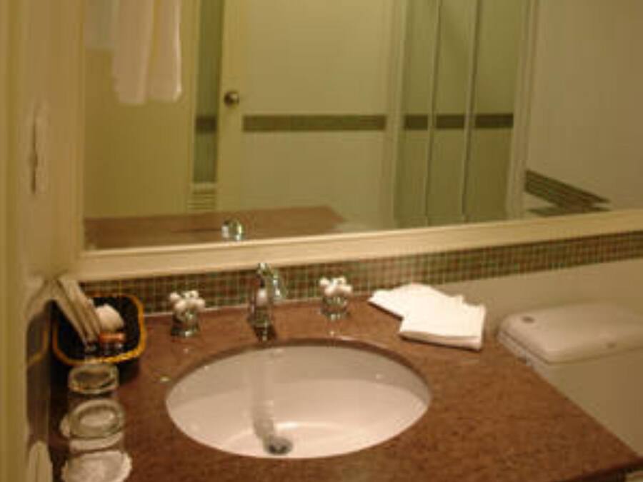 Un baño con lavabo, espejo y ducha.