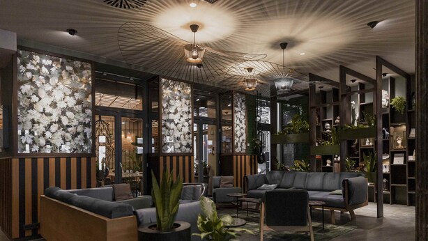 A modern lobby with sofas, a coffee table, and potted plants. - The Circus Hotel (Berlin)