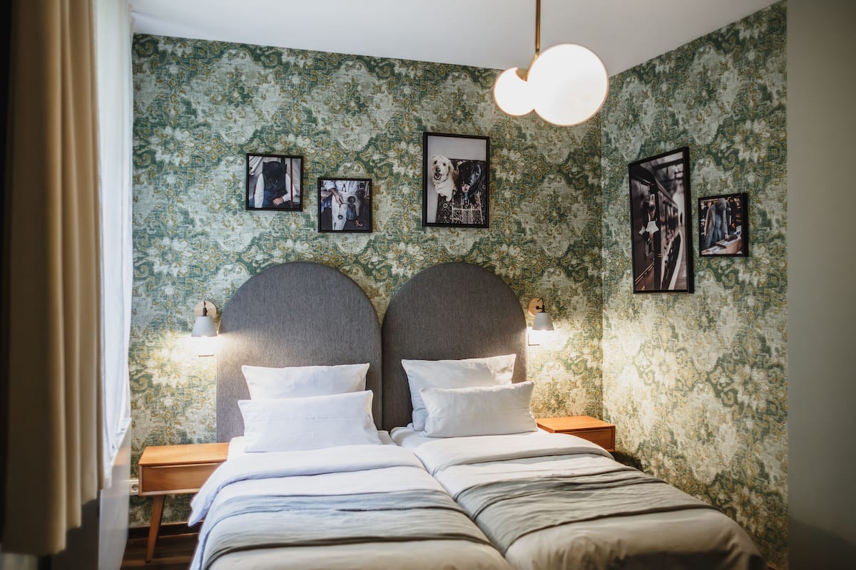 Ein Schlafzimmer mit einem großen Bett, zwei Nachttischen und einer Wand mit gerahmten Bildern.