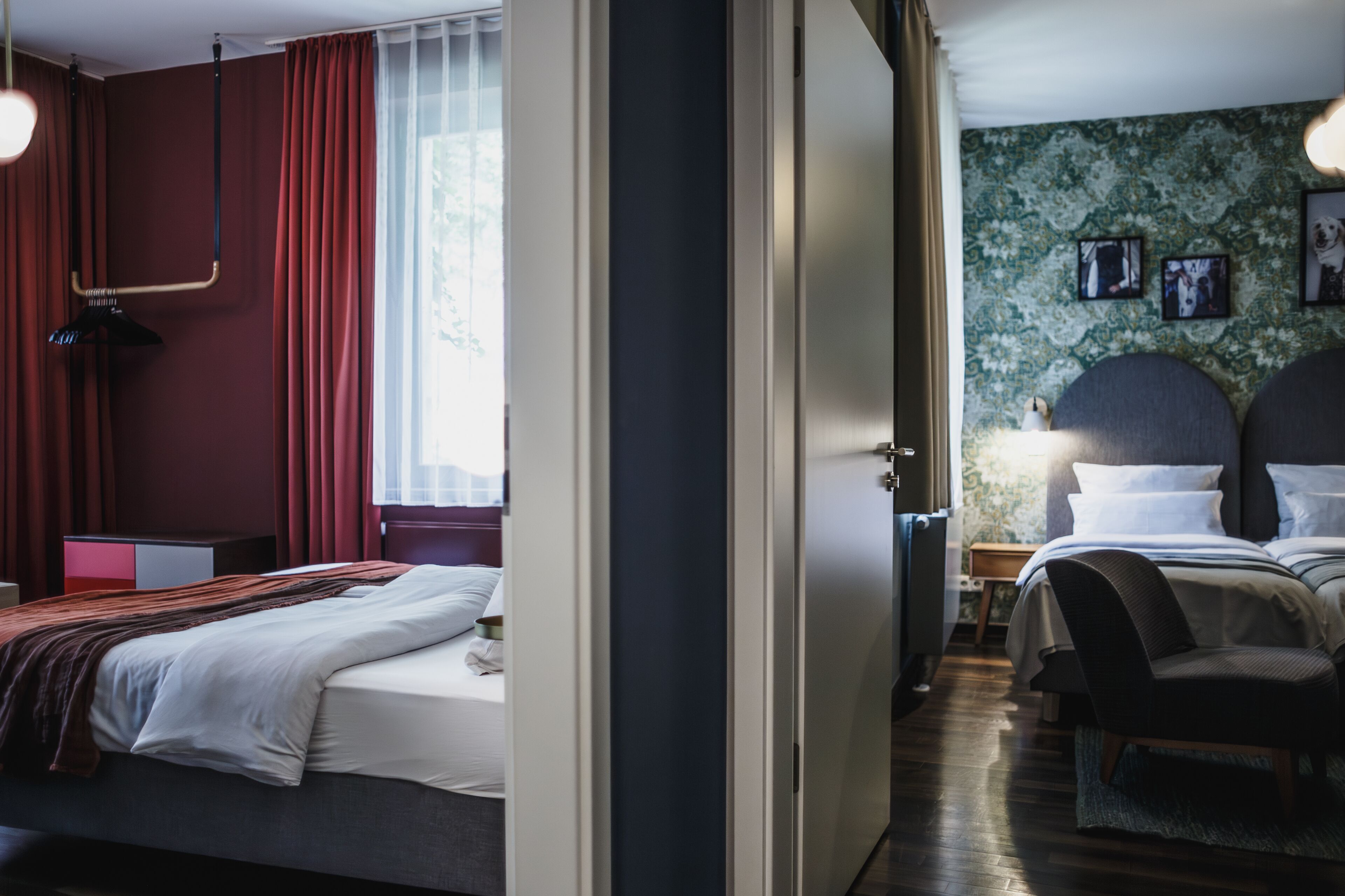 A hotel room with a bed, a desk, and a chair. There is a window with curtains and a lamp on the desk.