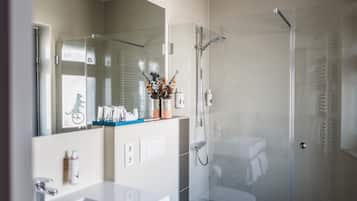 Een douche, een regendouche, designer toiletartikelen, een haardroger