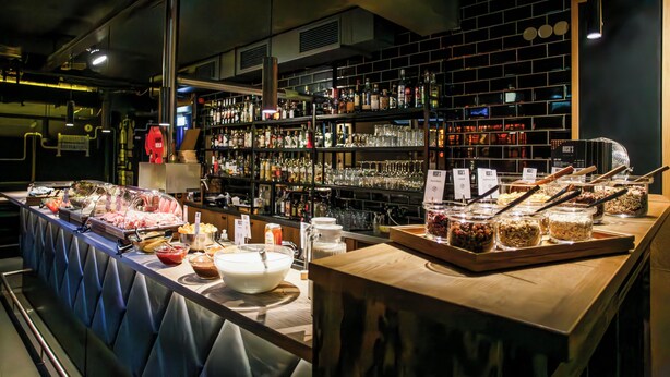 Ein reichhaltiges Buffet mit verschiedenen Speisen und eine Bar mit Flaschen und Gläsern.