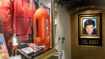 Una exhibición con un chaleco salvavidas, una chaqueta y un marco con el texto "THE HOFF".