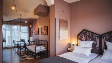 A modern hotel room with a bed, bedside table, and a view of the city.