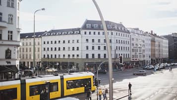 Une vue de rue avec un bâtiment portant l’inscription « The Circus Hotel » et un tramway jaune.