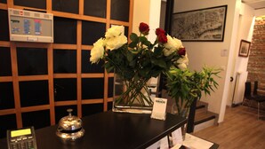 A reception desk with a cash register, a card reader, and a vase of flowers. - Hotel La Chartreuse (Toulouse)