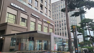 Un hotel llamado REBOUND con una fachada moderna, múltiples ventanas y una entrada visible.