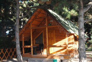 A wooden cabin with a porch, a table, and chairs. - Elki-Palki (Sovinion)