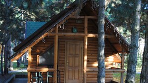 A wooden cabin with a large door, a window, and a number '3' sign. - Elki-Palki (Sovinion)