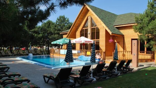 A wooden cabin with a pool and lounge chairs. - Elki-Palki (Sovinion)