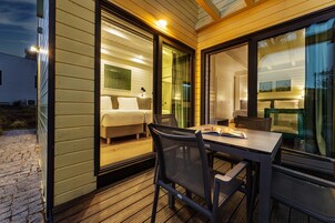 Una habitación moderna y bien iluminada con una cama, una mesa y sillas.