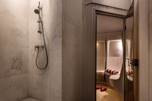 Un bagno con doccia, WC e portasciugamani.