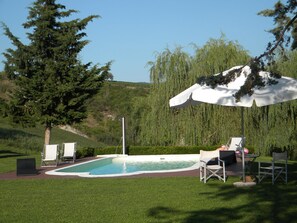 Alberca al aire libre, sombrillas en la alberca y camastros 
