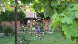 A garden with a house in the background. - Agriturismo Podere Assolatina (San Casciano dei Bagni)