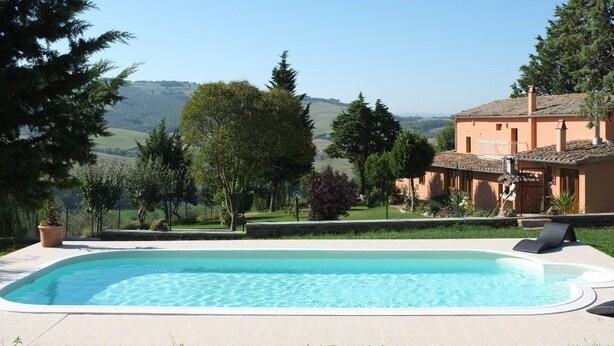 A swimming pool with a view of a house and hills in the background. - Agriturismo Podere Assolatina (San Casciano dei Bagni)